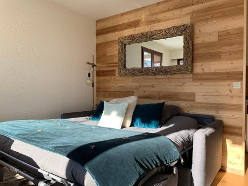 a bedroom with a bed with a mirror on the wall at Appartement Le Grand-Bornand, 1 pièce, 4 personnes - FR-1-467-91 in Le Grand-Bornand