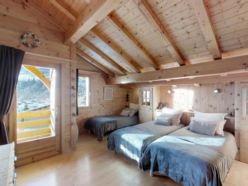 two beds in a room with wooden ceilings at Chalet Le Grand-Bornand, 6 pièces, 11 personnes - FR-1-467-58 in Le Grand-Bornand