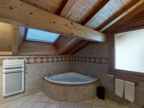 Cette chambre comprend une salle de bains pourvue d'une grande baignoire. dans l'établissement Chalet spacieux pour 11 pers., proche pistes de ski, jardin, BBQ, équipements enfants - Le Grand-Bornand - FR-1-467-58, au Grand-Bornand