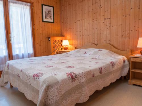 - une chambre avec un lit doté d'une couverture fleurie dans l'établissement Appartement 6 pers. au pied des pistes, parking - FR-1-467-94, au Grand-Bornand