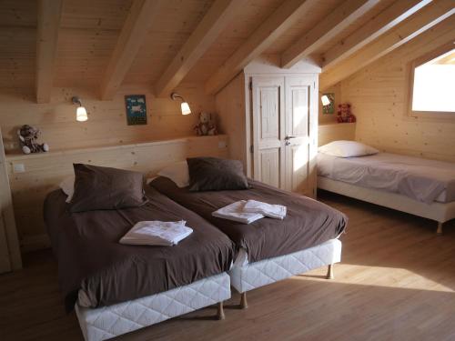 a bedroom with two beds in a cabin at Chalet spacieux pour 10 personnes avec parking et animaux admis - FR-1-467-71 in Le Grand-Bornand