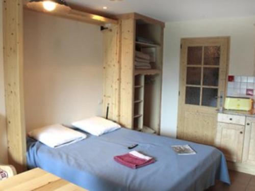 - une chambre avec un lit bleu dans l'établissement Charmant studio 24m² avec accès piscine, près des pistes et centre du Grand-Bornand - FR-1-467-103, au Grand-Bornand