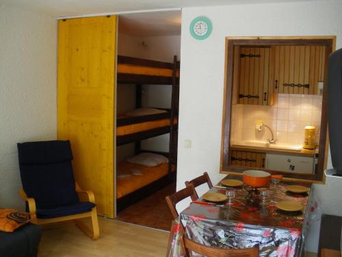 une chambre avec une table et une cuisine avec des lits superposés dans l'établissement Studio cosy au pied des pistes, 4 pers, Le Grand-Bornand Chinaillon, cuisine équipée - FR-1-467-117, au Grand-Bornand