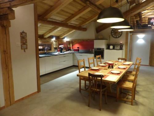une grande cuisine avec une table et des chaises en bois dans l'établissement Appartement 4* pour 10 pers. avec cheminée et bain norvégien, proche pistes - Le Grand-Bornand - FR-1-467-100, au Grand-Bornand