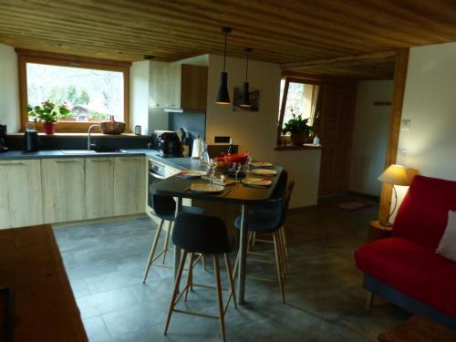 une cuisine avec une table et des chaises dans une pièce dans l'établissement Charmant appartement en chalet historique avec bain norvégien, proche pistes et commodités - FR-1-467-96, au Grand-Bornand