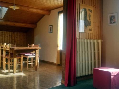 une salle à manger avec une table et un rideau rouge dans l'établissement Chalet spacieux 12 pers, proche pistes et navette, parking privé - FR-1-467-121, au Grand-Bornand