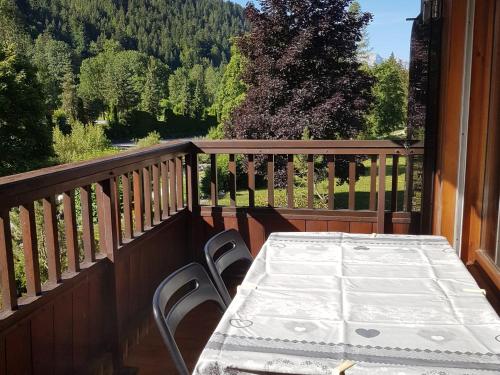 une table sur un balcon avec vue sur les montagnes dans l'établissement Appartement cosy pour 6 au Grand-Bornand, proche centre et navette gratuite - FR-1-467-122, au Grand-Bornand