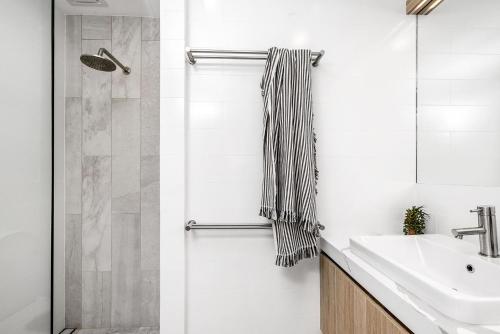 a bathroom with a sink and a shower at A Perfect Stay - 11 James Cook Apartments in Byron Bay