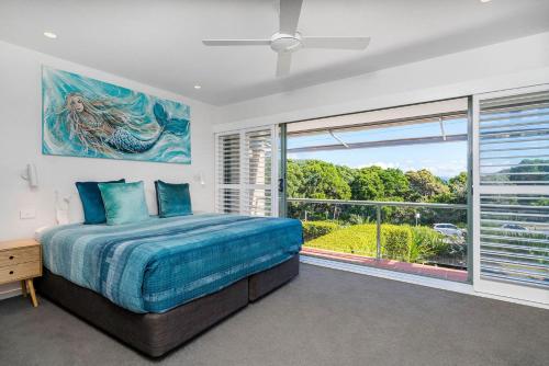 a bedroom with a bed and a large window at A Perfect Stay - 4 James Cook Apartments in Byron Bay