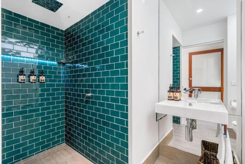 a bathroom with a sink and blue tiles at A Perfect Stay - 4 James Cook Apartments in Byron Bay