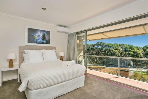 a bedroom with a bed and a large window at A Perfect Stay - 2 James Cook Apartments in Byron Bay