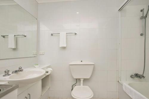 a bathroom with a toilet and a sink and a shower at A Perfect Stay - 2 James Cook Apartments in Byron Bay