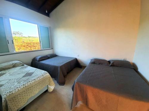 una habitación con dos camas y una ventana en Casa em capitólio Mg, en Capitólio