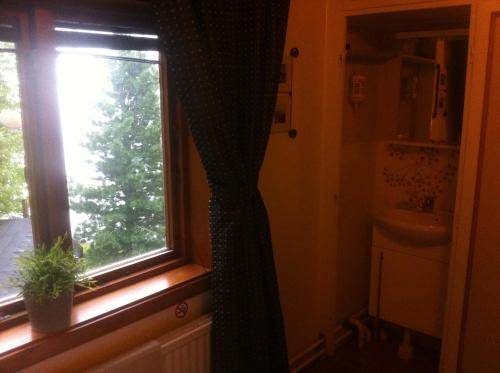 a bathroom with a window with a plant next to it at Tärnaby Rooms & Apartments in Tärnaby