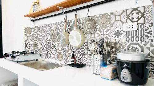 una cocina con fregadero y una pared con azulejos en Panglao Lofts, en Panglao