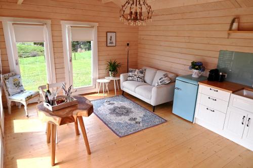 sala de estar con sofá y mesa en Avocate' Cottage en Whiritoa