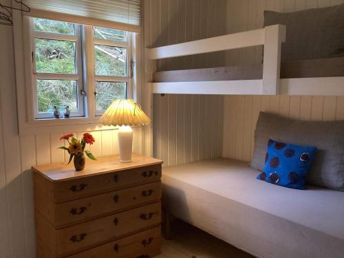 ein Schlafzimmer mit einem Etagenbett und eine Kommode mit einer Lampe in der Unterkunft 4 person holiday home in Blokhus-By Traum in Blokhus