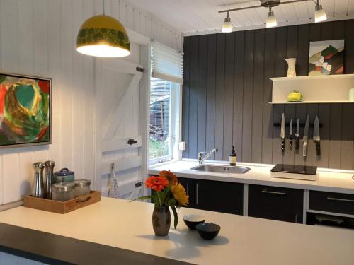 eine Küche mit einer Vase mit Blumen auf einer Theke in der Unterkunft 4 person holiday home in Blokhus-By Traum in Blokhus