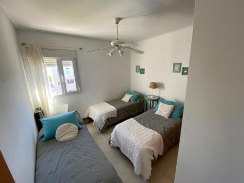 ein Schlafzimmer mit zwei Betten und einem Deckenventilator in der Unterkunft Jarillal in Las Grutas