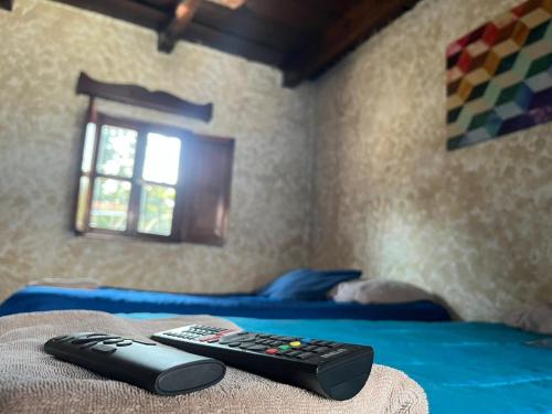 two remote controls sitting on the edge of a bed at Cristales de Antigua Hotel Cristal in Antigua Guatemala