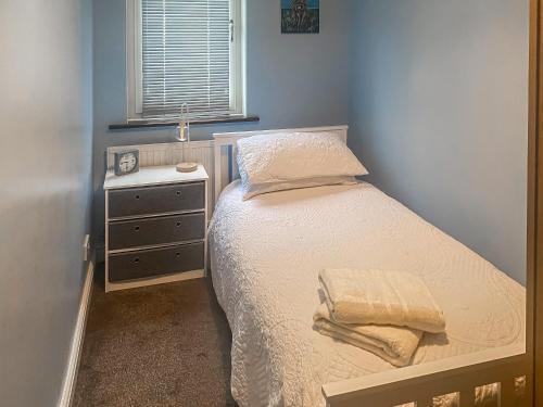 a small bedroom with a bed and a night stand at Beckside Court in Brampton