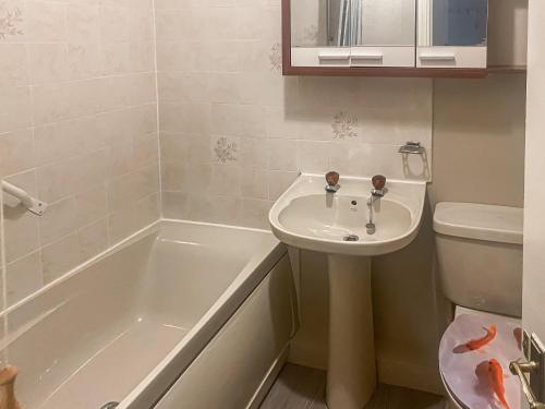 a bathroom with a sink and a tub and a toilet at Beckside Court in Brampton