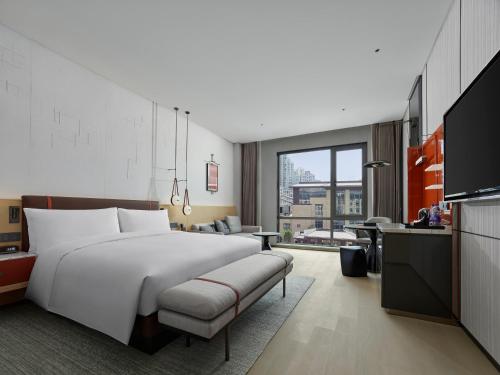 a bedroom with a large white bed and a couch at DoubleTree By Hilton Cangnan in Cangnan