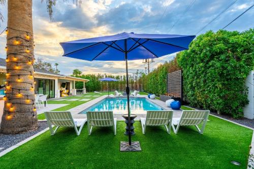 a blue umbrella sitting in the grass next to a pool at The Agave Oasis in Scottsdale