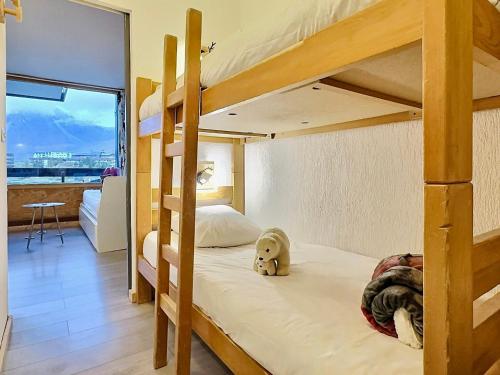 - une chambre avec des lits superposés et un ours en peluche au sol dans l'établissement Studio cabine cosy à Tignes avec balcon, proche pistes et commerces. Wifi inclus. - FR-1-411-905, à Tignes
