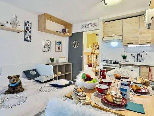 un salon avec une table avec de la nourriture dessus dans l'établissement Studio cabine cosy à Tignes avec balcon, proche pistes et commerces. Wifi inclus. - FR-1-411-905, à Tignes