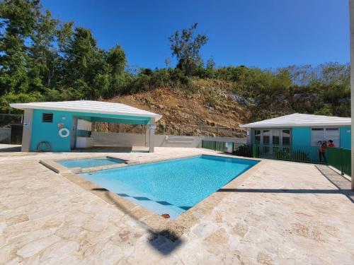 ein Pool mit einem Gebäude und einem Haus in der Unterkunft Casa Arrecife 28 in Cabo Rojo