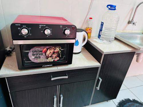 a stove in a kitchen with a sign on it at Tom’s Homestay in Batu Caves