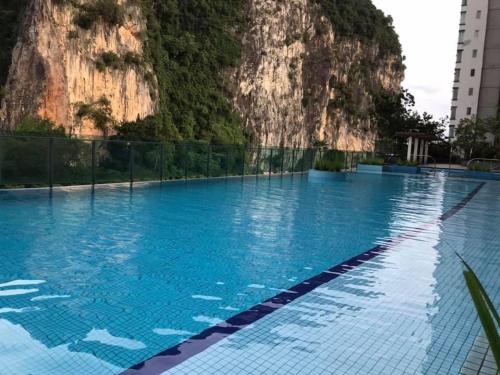a swimming pool with a mountain in the background at Tom’s Homestay in Batu Caves