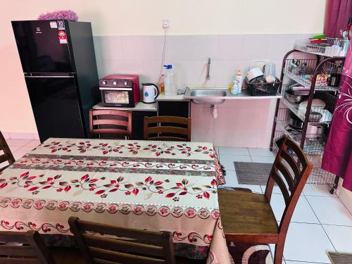 a kitchen with a table with a table cloth with birds on it at Tom’s Homestay in Batu Caves