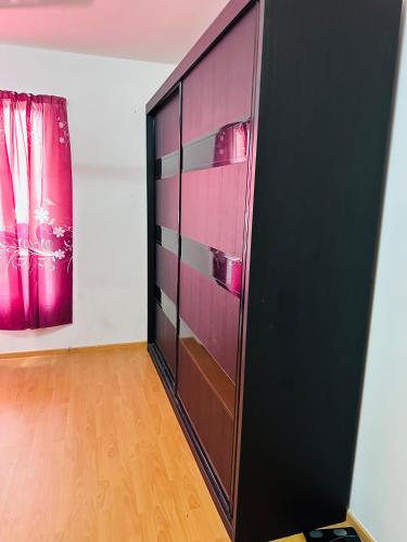 a black cabinet in a room with a painting at Tom’s Homestay in Batu Caves