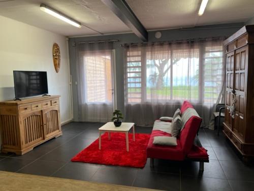 sala de estar con sofá rojo y mesa en BLACK CANE LODGE, en Saint-Claude