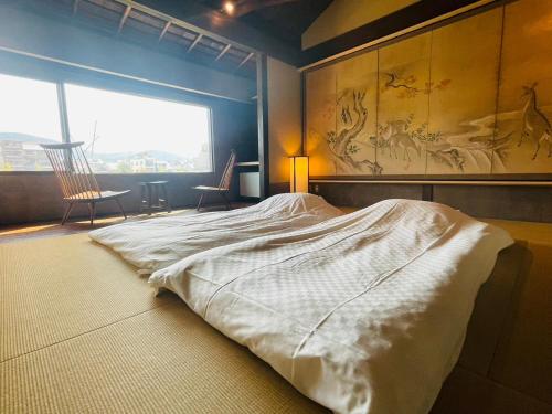 um quarto com uma cama grande e uma janela grande em 京都　水凪庵　Kyoto Mizunagian em Giommachi