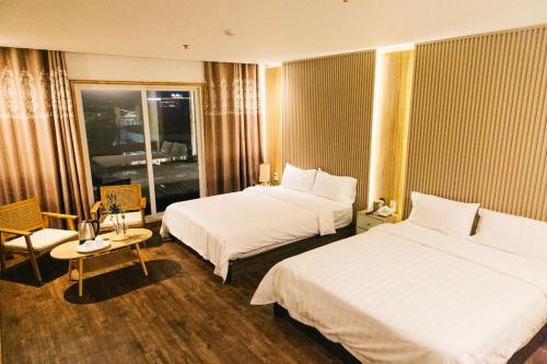 Habitación de hotel con 2 camas y ventana en THE KOA Hotel & Spa en Ángeles