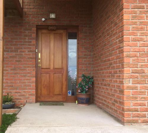 a brick building with a wooden door with a potted plant at House with Magnificent Panoramic Harbor Views Howrah in Howrah