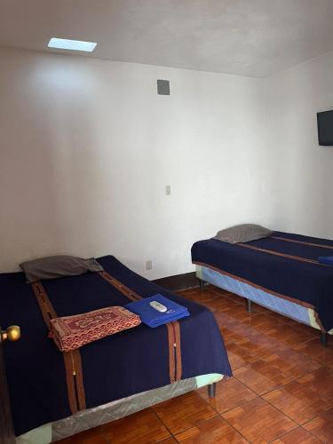 a room with two beds in a room at Cristales de Antigua Hotel Cristal in Antigua Guatemala