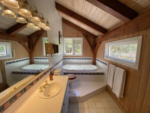 a large bathroom with two sinks and a tub at Peaceful & secluded, yet close to town. in Mariposa