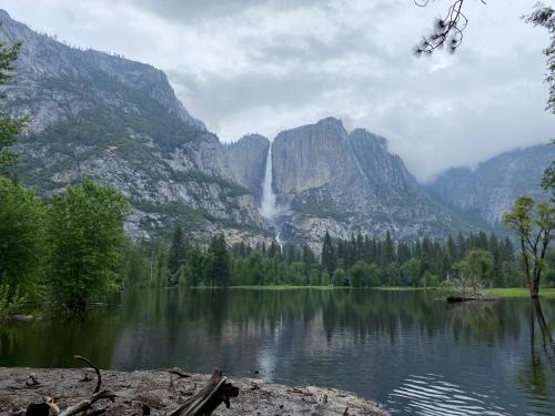 a waterfall in front of a mountain with a lake at Peaceful & secluded, yet close to town. in Mariposa