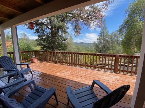a deck with chairs and a view of the woods at Peaceful & secluded, yet close to town. in Mariposa