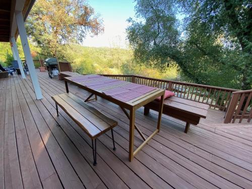 a picnic table and benches on a deck at Peaceful & secluded, yet close to town. in Mariposa