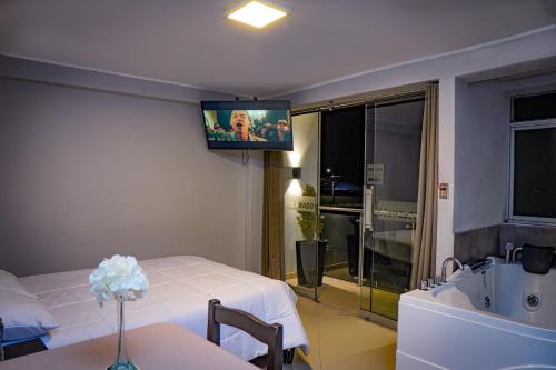 pokój hotelowy z łóżkiem i telewizorem na ścianie w obiekcie Hotel Prado w mieście Huancayo