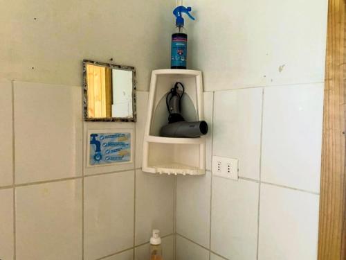 - un coin salle de bains avec une bouteille sur le mur dans l'établissement Cabañas El Colibrí, à Algarrobo