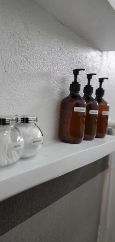 three bottles of soap sitting on a shelf at Country Home in Silang Tagaytay in Silang