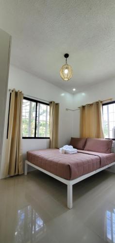 duże łóżko w pokoju z oknami w obiekcie Country Home in Silang Tagaytay w mieście Silang
