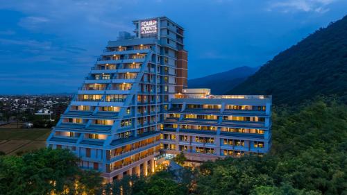 Un alto edificio blu con un cartello sopra di Four Points by Sheraton Yilan Jiaoxi a Jiaoxi