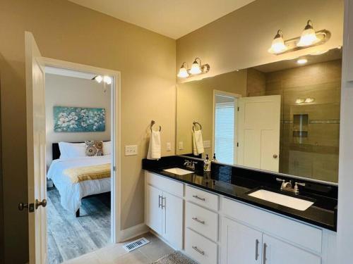 Luxury 4 Bedroom Home and private deck by MCG 6 في أوغوستا: حمام مع حوض وغرفة نوم مع سرير